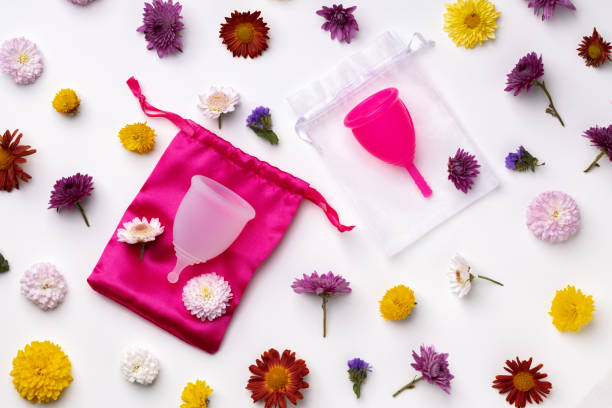Menstrual cup on floral pattern background top view Menstrual cup on floral pattern background top view, copy space boiling menstrual cup stock pictures, royalty-free photos & images
