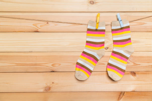istock multicolored socks hanging on a clothesline with clothespins on a wooden background 1292878887