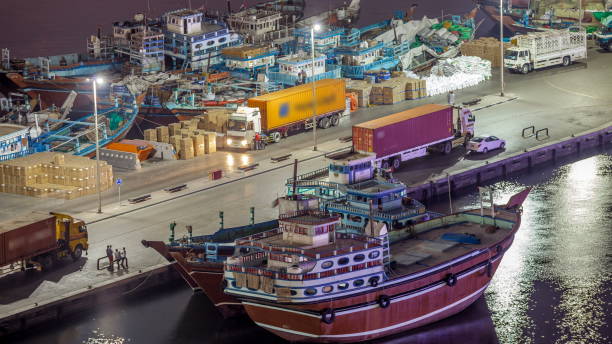 Loading a ship in Port Said night in Dubai, Deira creek, UAE. Aerial top view from above with many old boats and street lights