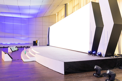 Empty conference hall with empty white projector screen, side view