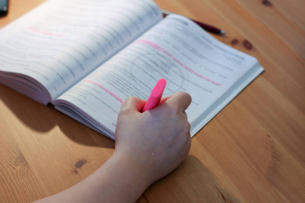 istock A hand holding highlighter pen. Underlining important text with highlighter pen. Education ,student concept. 1292880689