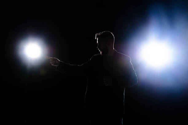 istock Silhouette of man pointing isolated on black dark background in lanterns light 1292881578