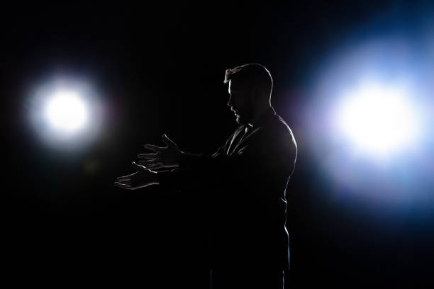 istock Silhouette of man pointing bad isolated on dark background in lanterns light 1292881579