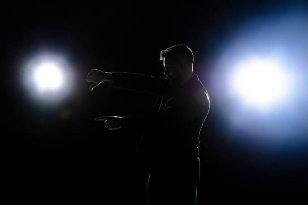 istock Silhouette of man pointing bad isolated on dark background in lanterns light 1292881582