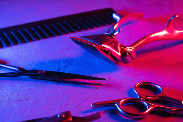 red and blue psychedelia cinematic aesthetics. on surface are old barber tools. Vintage manual hair clipper comb razor hairdressing scissors. horizontal orientation