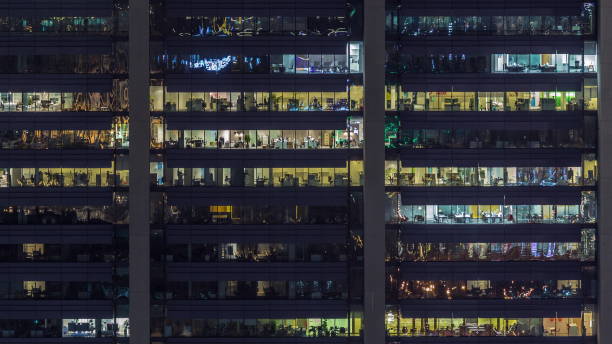 istock Office windows on facade of a modern skyscraper showing business activity 1292887320