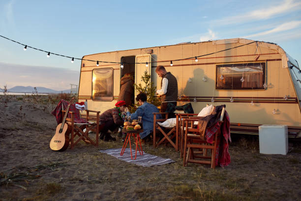 grupo de amigos organizando festa de ano novo em frente ao trailer de camper - caravana atrelado - fotografias e filmes do acervo