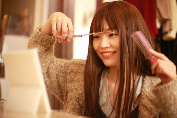 istock A woman who cuts her bangs herself 1292893619
