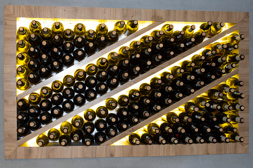 wine bottles in a wooden rack in the wine cellar. Storage of wine in wooden niches