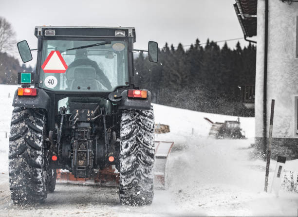 istock Tractor With Snowplow Clearing Snow From a Country Road 1292898527