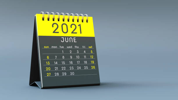 istock 2021 calendar notebook with June page in yellow colors, standing on a light gray background 1292898678
