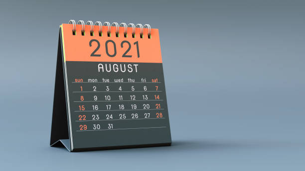 2021 calendar notebook with August page in orange colors, standing on a light gray background
