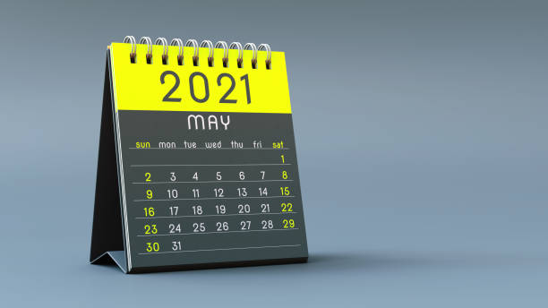 istock 2021 calendar notebook with May page in yellow colors, standing on a light gray background 1292899028