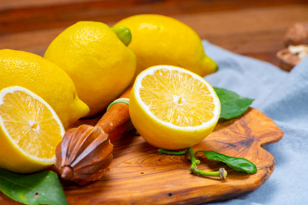 limoni italiani gialli freschi maturi e spremiagrumi di legno, nuova vendemmia - neapolitan specialty foto e immagini stock