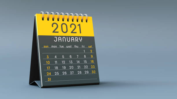 istock 2021 calendar notebook with January page in yellow colors, standing on a light gray background 1292899729