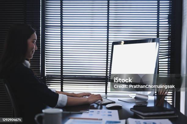 A Concentrate Businesswoman Using Computer And Analysis Investment With Chart At Office Desk Stock Photo - Download Image Now