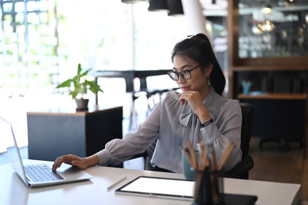 istock Businesswoman in eye glasses using computer laptop for online software for data analysis in office. 1292904863