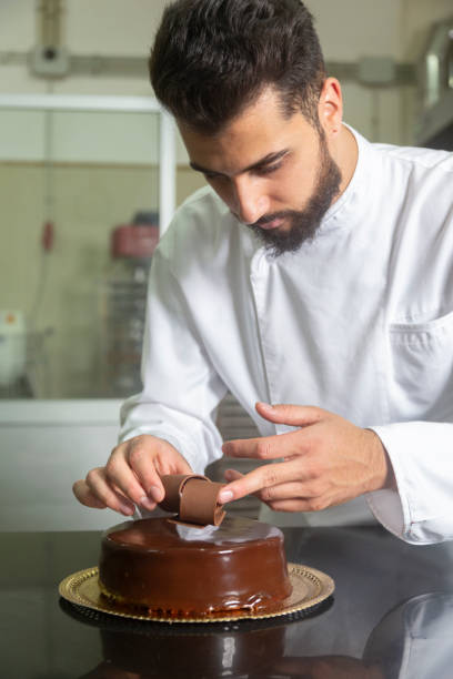 istock Pastry chef finishing decorating a chocolate cake 1292904954