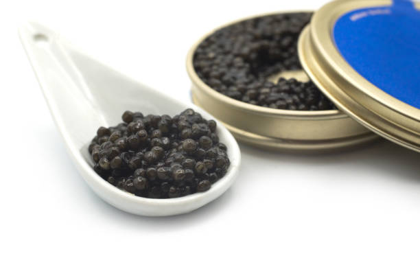 istock caviar in a white ceramic spoon with the metalllic box on white background 1292905573