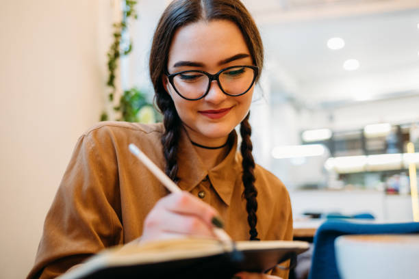 istock Woman with glasses writes in a notebook 1292906197