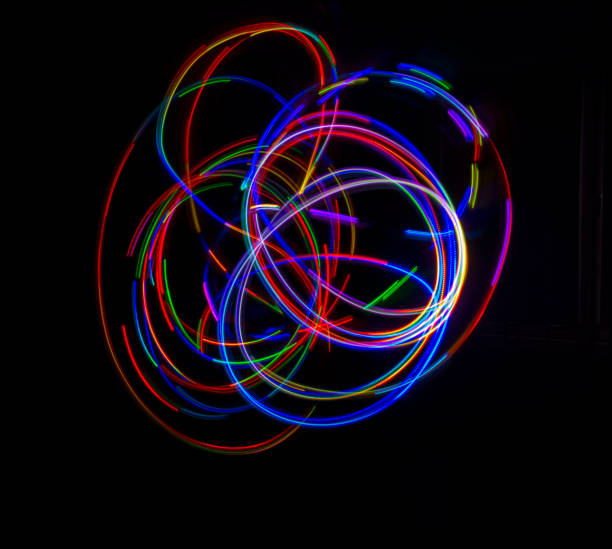 istock Abstract multicolored lines drawn by light on a black background 1292909489