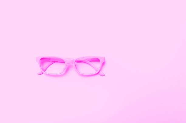 istock Pink glasses on a pink background. Top view, space for your text. 1292913599