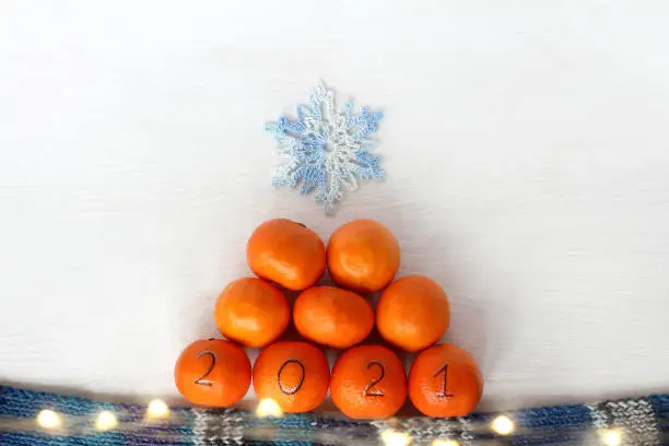 pyramid of orange fruits with a knitted blue snowflake on top
