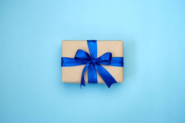 istock Gift box with blue ribbon bow on blue background. 1292914958