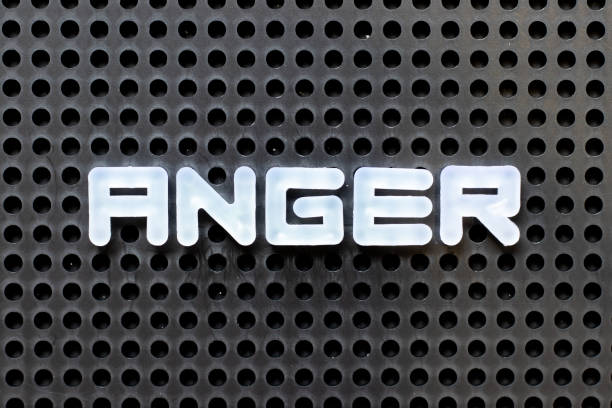 istock White color alphabet with word anger on black pegboard background 1292915813