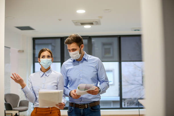 istock Two young employees wearing masks on work because of Corona virus. 1292916100