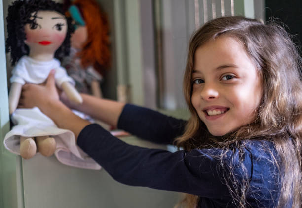 istock Girl holding a doll and looking at the camera 1292918067