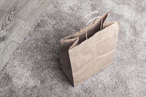 Recycling paper bag stands on a gray carpet, top view