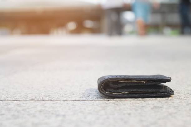 istock A black wallet fell on the pedestrian walkway before someone picked it up. 1292918240
