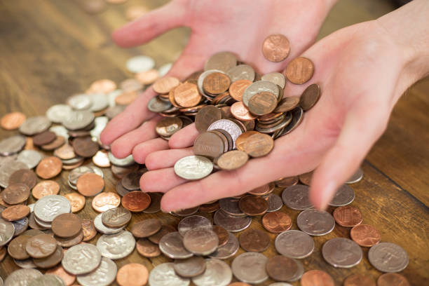 istock US Coins, scattered on table and in hands. 1292922774