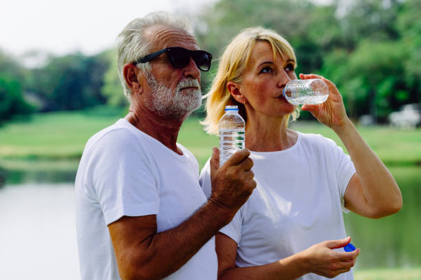 istock Couples Caucasian Elderly sitting in the park talk to each other with smile 1292923619
