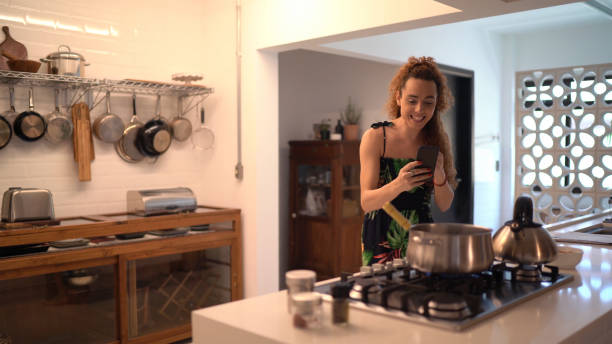 istock Transgender woman using smartphone doing a video call or vlogging while cooking at home 1292924546