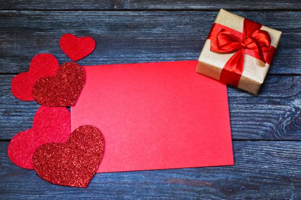 istock Greeting card. red hearts, gift box and paper space for text on a wooden background.  Copy space, flat lay. Valentine's Day. Holiday concept. 1292928362