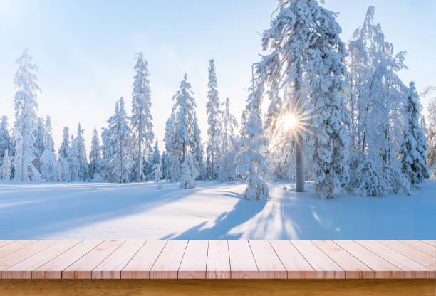istock Wooden board with snowy forest background. Empty wooden table with copy space 1292928556