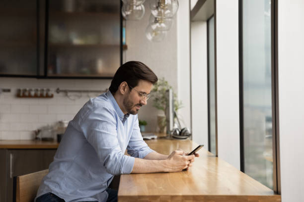 istock Young man look at smartphone screen texting online 1292931068