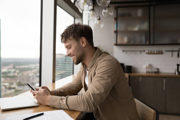 istock Smiling Caucasian man use smartphone in office 1292931117