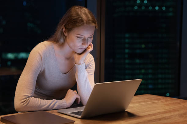 istock Female employee work on computer in office at night 1292931165