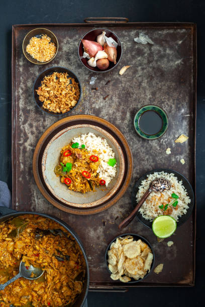 uma visão de alto ângulo de casa feita vegan indonésio jackfruit rendang servido com arroz em um prato marrom e acompanhamentos - accompaniments - fotografias e filmes do acervo