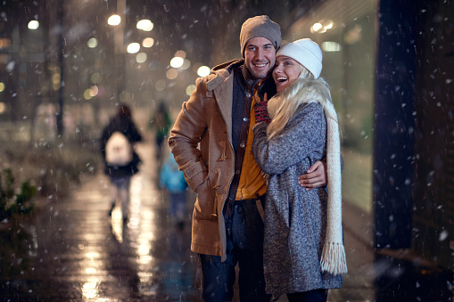 couple having good time together on a snowy weather in the city. Love, together, walk, snow, city