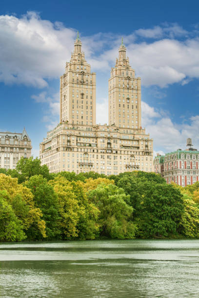 central park in autumn colors (foliage), lake and the san remo co-operative building, manhattan, new york. - autumn park central park lake foto e immagini stock