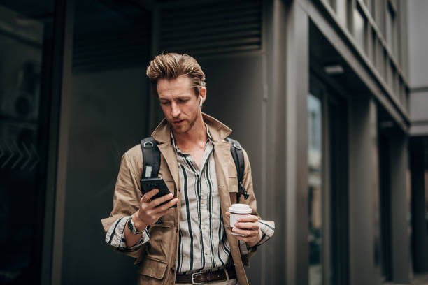 istock Modern man using phone on the street in city 1292933437