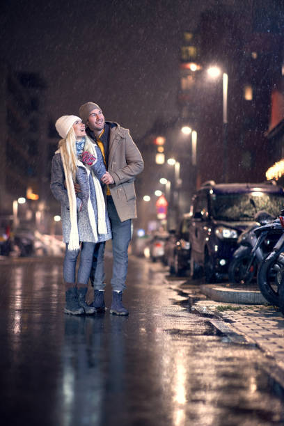 istock young couple looking up, smiling, watching snow falling 1292934018