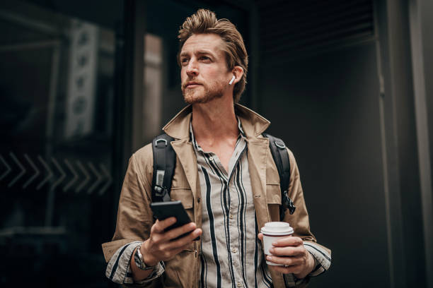 istock Modern man using phone on the street in city 1292934160