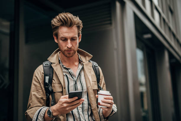 istock Modern man using phone on the street in city 1292934469