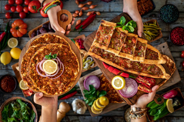 zwei menschen essen traditionelle türkische küche, lahmacun und kiymali pide und kusbasili pide. - pita stock-fotos und bilder