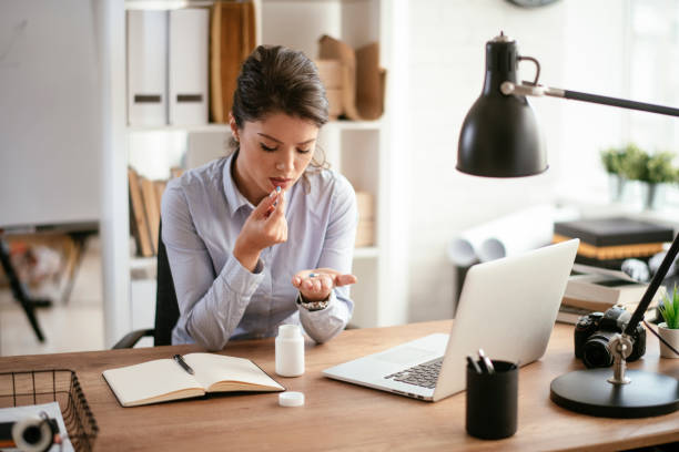 istock Young businesswoman drinking medicine pill. 1292942087